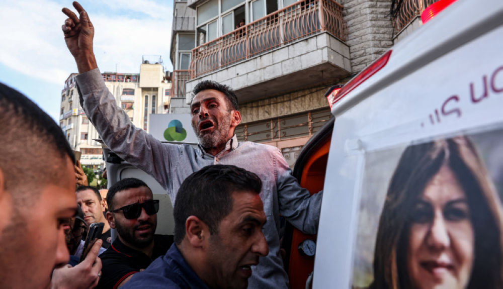 Un hombre palestino reacciona mientras el cuerpo de la periodista Shireen Abu Akleh es llevado a las oficinas de Al Jazeera. Los ciudadanos señalan a las fuerzas israelíes de perpetrar el homicidio. /AFP.