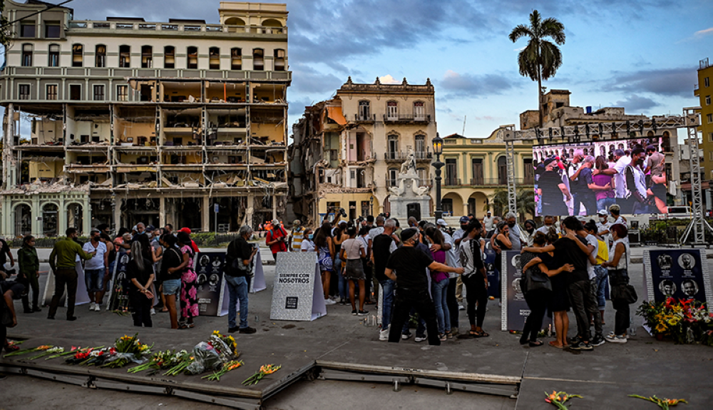 Cubanos participan en la vigilia por las víctimas de la explosión en el Hotel Saratoga en La Habana.AFP