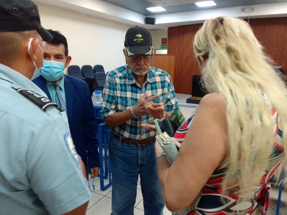 El excoronel Sigifredo Ochoa Pérez entrega sus pertenencias antes de ser esposado, este martes. Jaime López