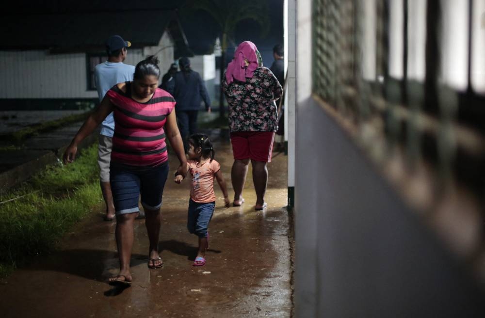 Una mujer y su hija caminan en un refugio temporal en Blufields, por la tormenta 