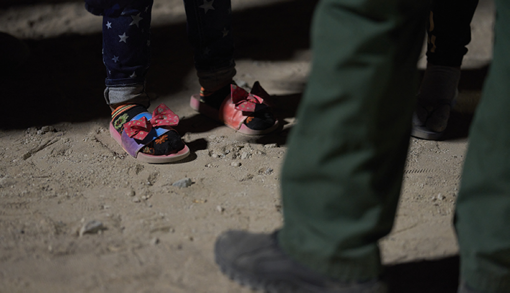 Menor migrantes es atendida por un agente de la Patrulla Fronteriza.AFP