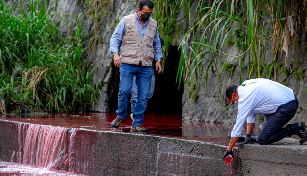 El titular de Medio Ambiente, Fernando López y el presidente de ANDA, Rubén Alemán verifican el vertido en la quebrada 5 de Noviemre. Cortesía