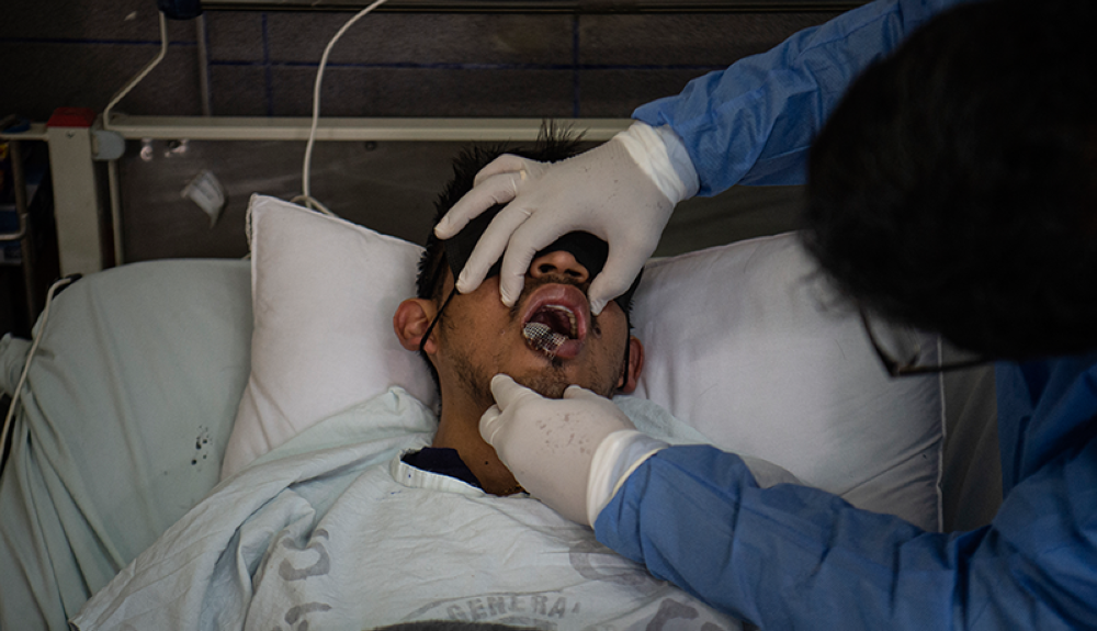 Un médico revisa a un paciente con llagas causadas por una infección de viruela del mono en el área de aislamiento para pacientes con viruela del simio en el hospital Arzobispo Loayza, en Lima.AFP