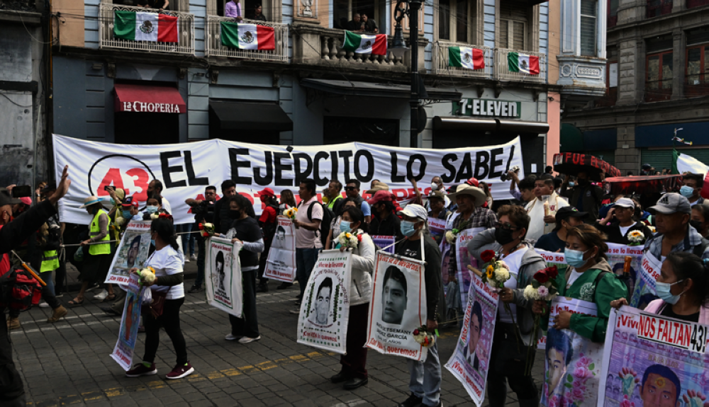 La gente grita consignas durante una marcha en la Ciudad de México el 26 de septiembre de 2022, con motivo del octavo aniversario de la desaparición de 43 estudiantes de la escuela de formación docente en Ayotzinapa. AFP. 