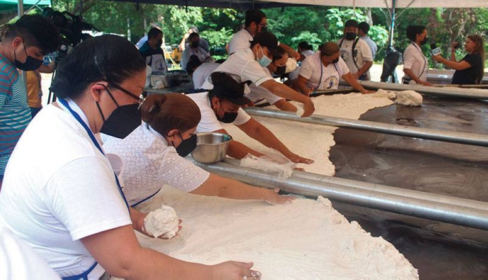 28 pupuseras se encargan de cubrir de masa una plancha circular que posee las mismas medidas de la gigantesca pupusa. / G. Aquino