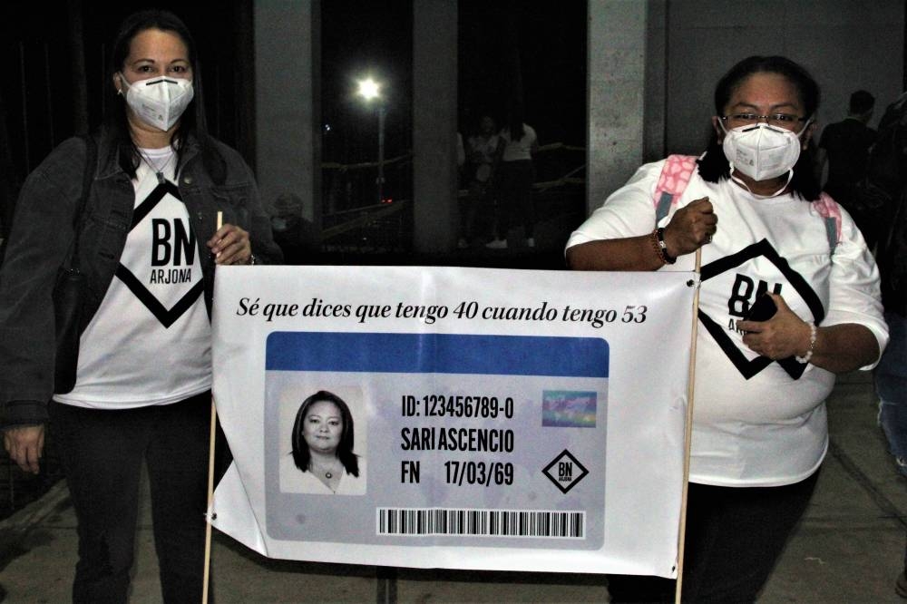 Sari Ascencio es una de las más grandes fanáticas de Arjona. Junto a su amiga sostiene un banner que simula su documento de identificación con una frase que hace referencia al tema 