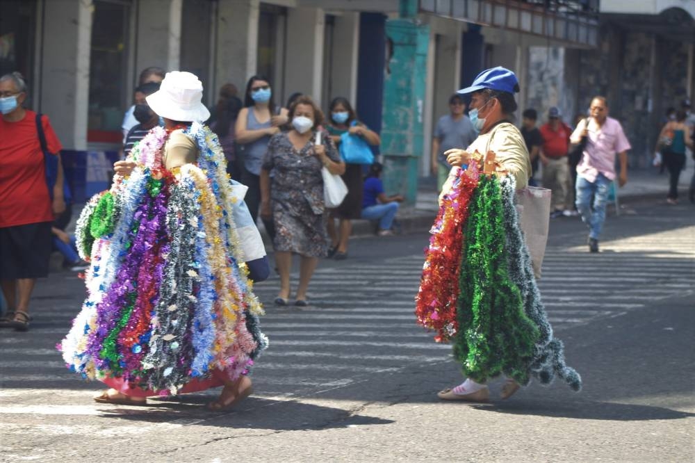 Muchas mujeres que labora en el sector comercio se dedican a vender adornos navideños desde noviembre en el centro de San Salvador. /G.A.
