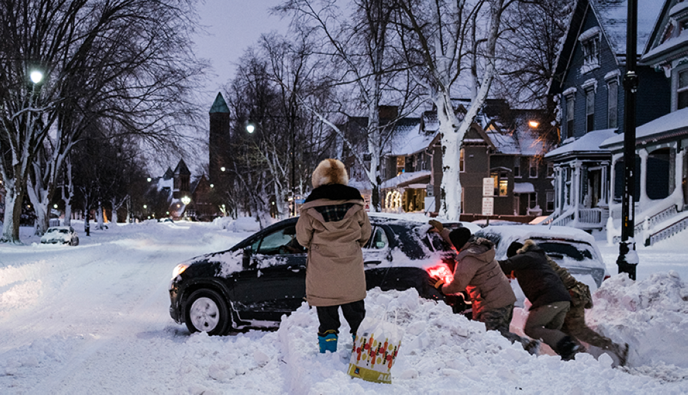 Miembros de la Guardia Nacional de Nueva York ayudan a liberar un automóvil atascado en la nieve en Buffalo, Nueva York.AFP