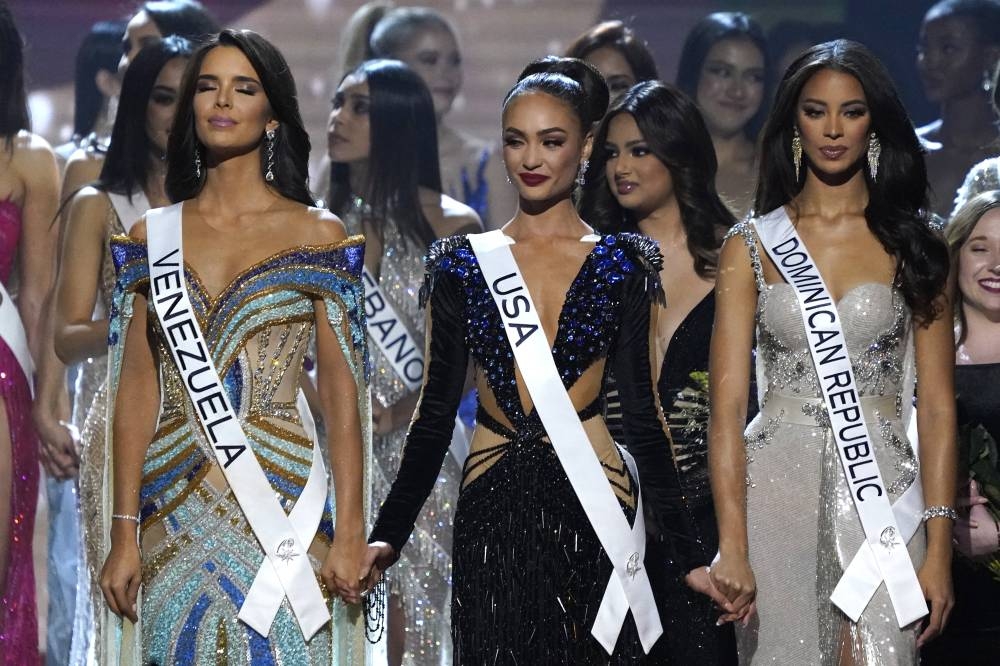 Miss Venezuela Amanda Dudamel, Miss USA R'Bonnie Gabriel and Miss Dominican Republic Andreina Martinez hold each other before the final judging during the 71st Miss Universe pageant at Ernest N.