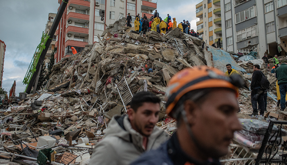 Los rescatistas buscan víctimas y supervivientes entre los escombros de un edificio que se derrumbó en Adana, Turquía.AFP