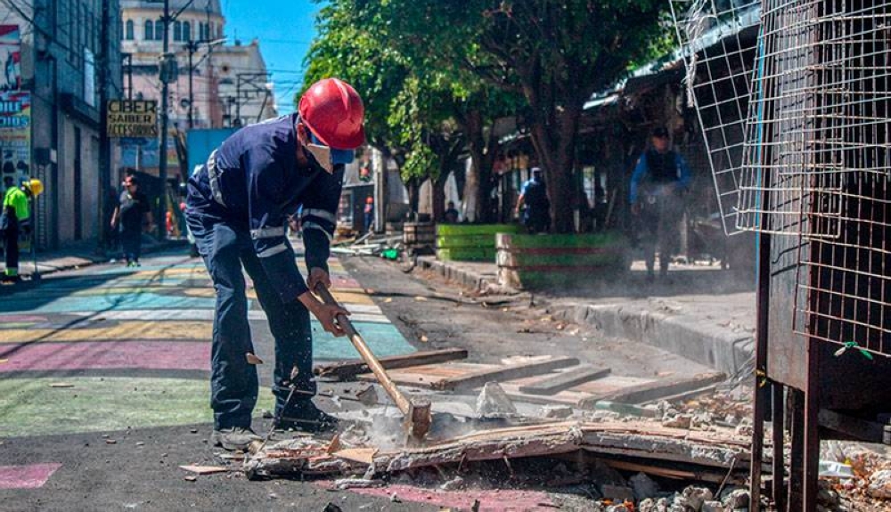 Empleados de la alcaldía limpian los restos de los puestos sobre la calle Delgado. / Lisbeth Ayala