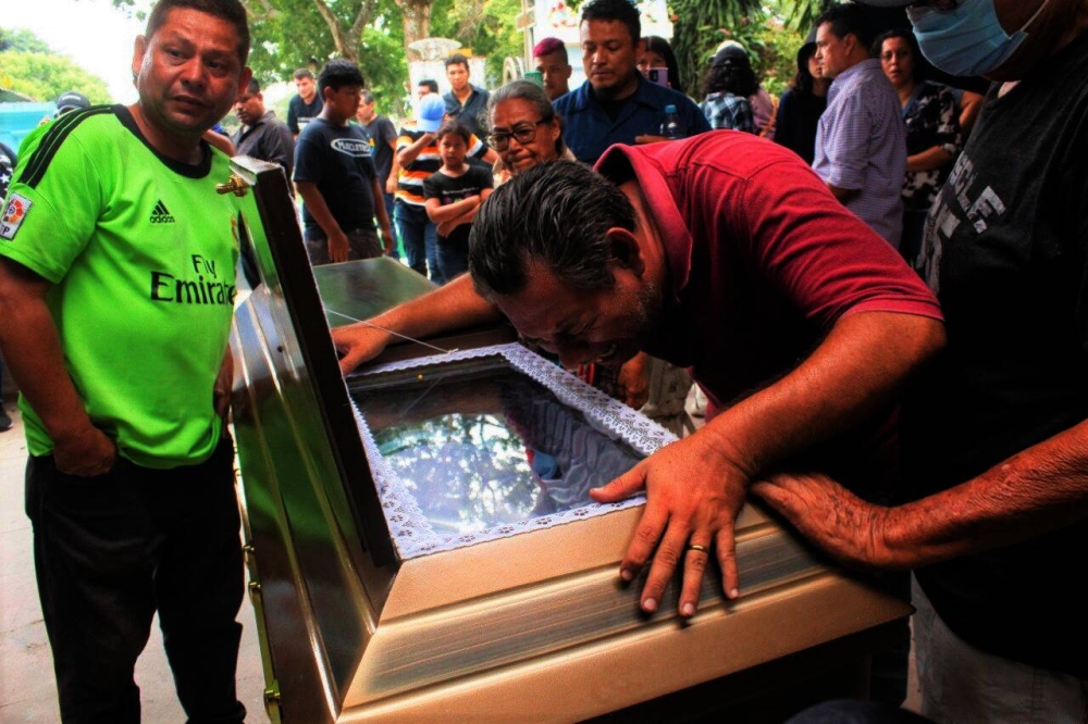 Previo al entierro de Néstor Alas uno de sus familiares llora sobre el ataúd. Foto Emerson Del Cid.