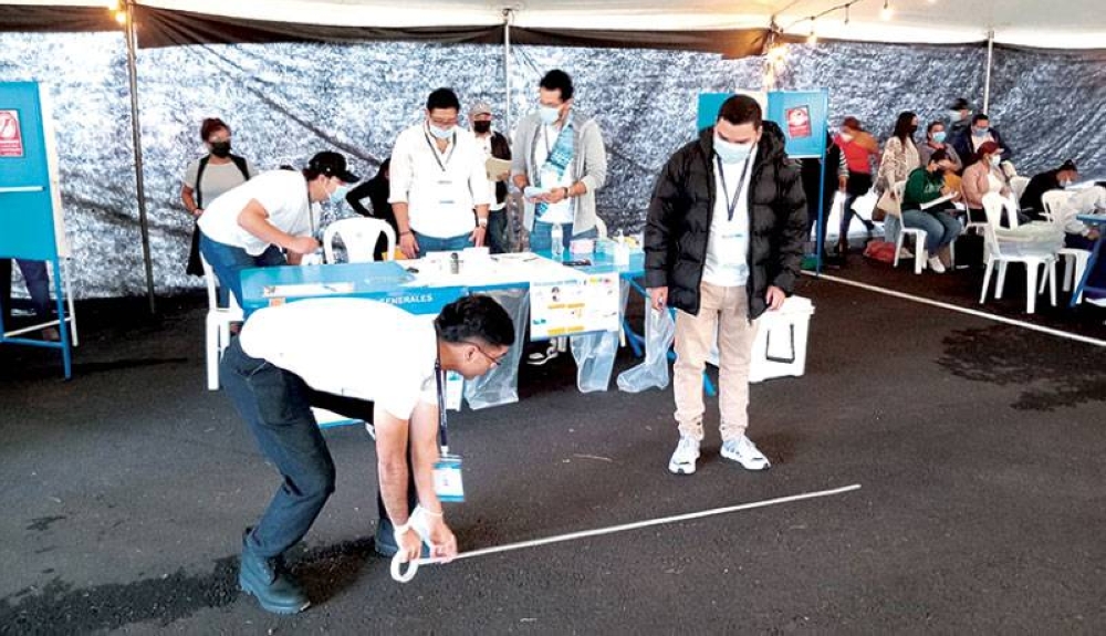 Jóvenes trazaban la línea de los votantes antes de recibir a los electores en una de las JRV en Ciudad de Guatemala. / J.M.