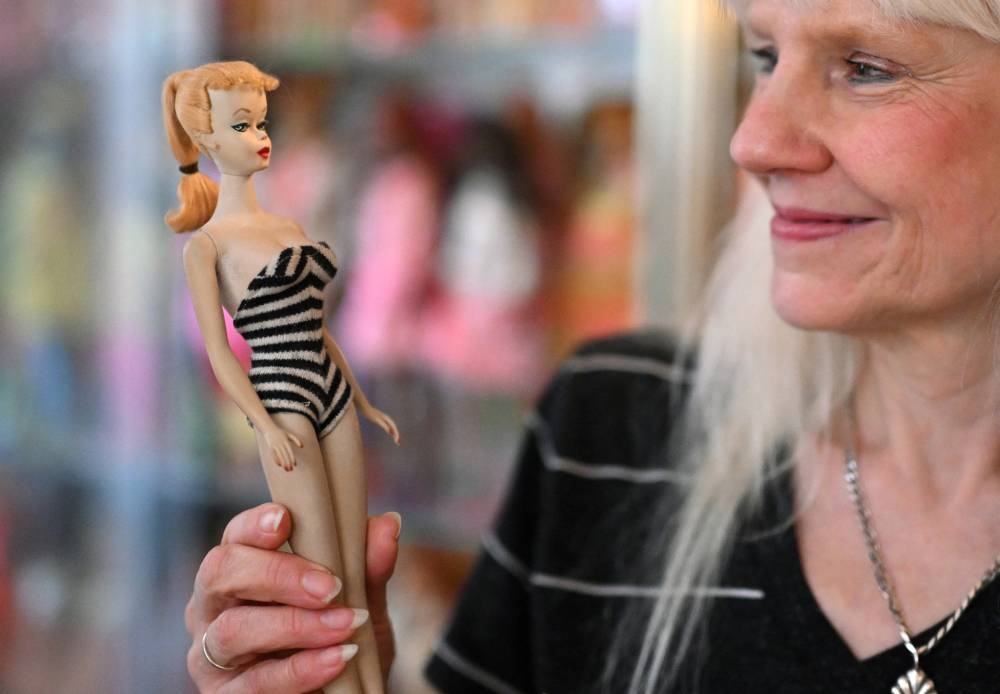 Dorfmann sostiene una muñeca de 1959, en su clínica de Barbies en Duesseldorf, Alemania. / Foto: AFP