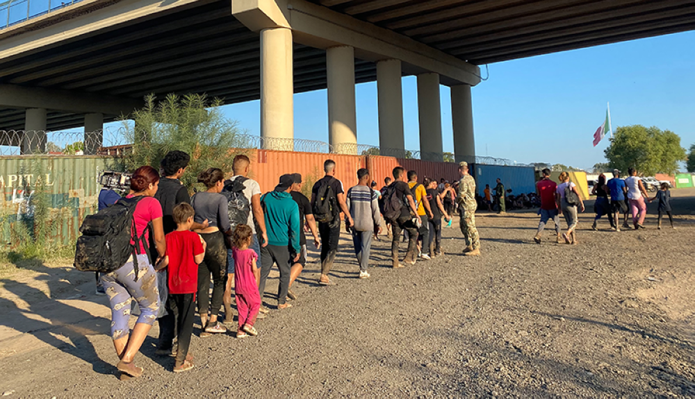 Migrantes venezolanos caminan por el lado estadounidense de la frontera después de cruzar desde México en Eagle Pass, Texas, donde se entregaron a las autoridades.AFP