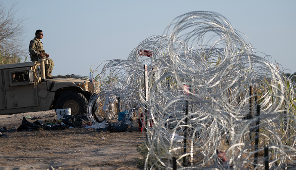 Un miembro de la Guardia Nacional de Texas observa mientras monitorea el río Grande en busca de migrantes en la frontera entre Estados Unidos y México en Eagle Pass, Texas.AFP