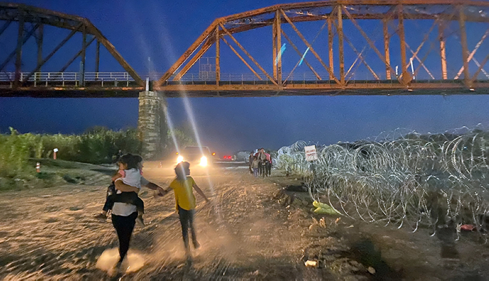 Migrantes caminan después de vadear el Río Grande en la frontera entre Estados Unidos y México en Eagle Pass, Texas.AFP