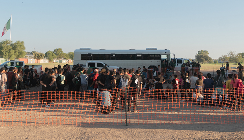 Los migrantes esperan ser procesados ​​por agentes de Aduanas y Protección Fronteriza de EE.UU. después de cruzar el Río Grande desde México.AFP