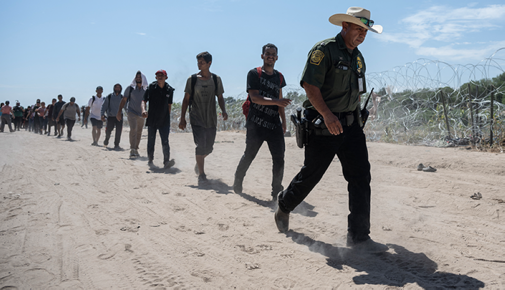 Un gente fronterizo guía a migrantes venezolanos para ser procesados en Eagle Pass, Texas.AFP