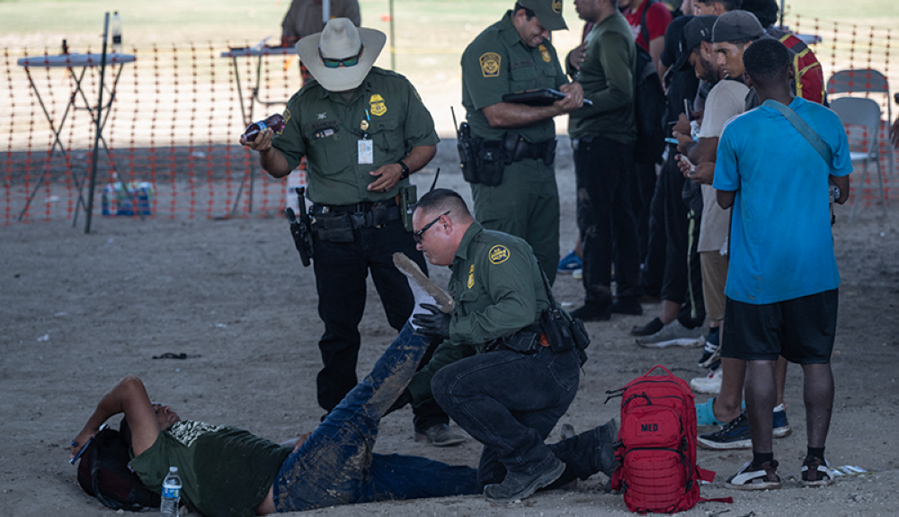 Miembros de la Patrulla Fronteriza de Estados Unidos ayudan a un migrante que se lesionó una pierna.AFP