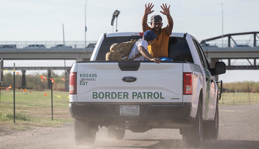 MIgrantes celebran haber cruzado mientras son transportados por agentes fronterizos a un centro de procesamiento en Texas. AFP