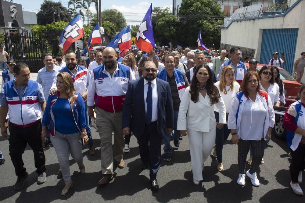 La fórmula presidencial de Arena, Joel Sánchez e Hilcia Bonilla, caminan junto al presidente del partido, Carlos García Saade, y otros miembros del partido. / Emerson del Cid.