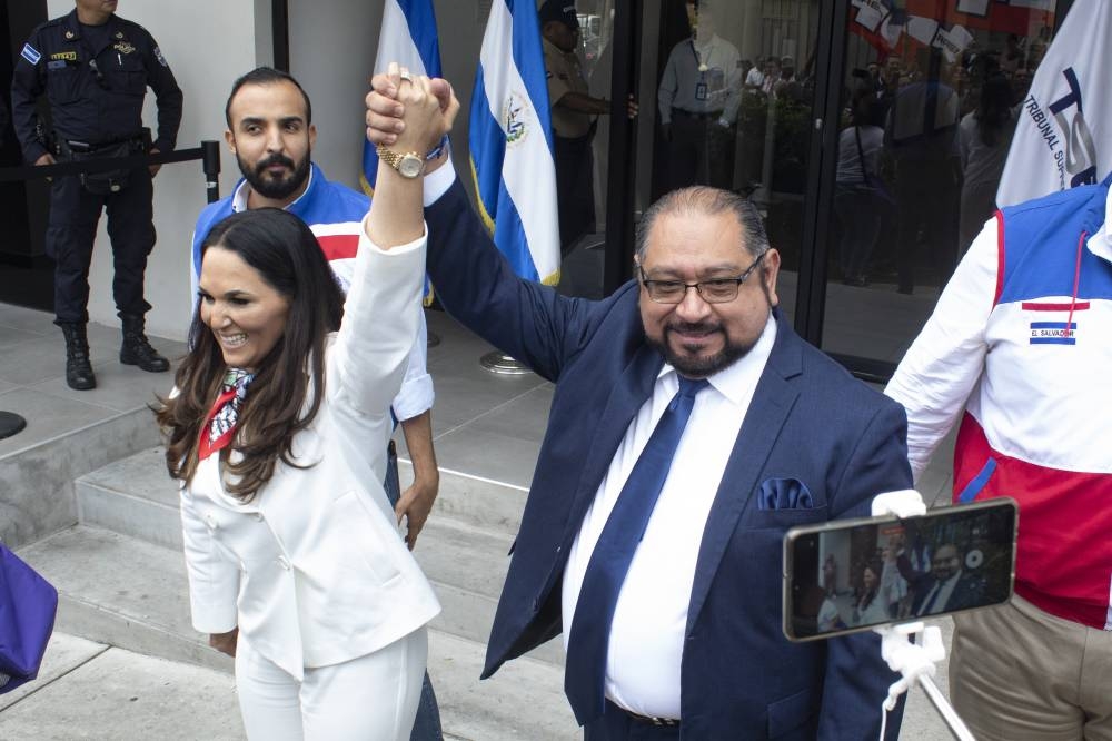 El candidato presidencial de Arena alza la mano a su compañera de fórmula, Hilcia Bonilla. Atrás, Cesar Reyes, diputado suplente y dirigente del partido. / Emerson del Cid.