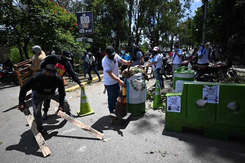 La gente bloquea una carretera durante una protesta exigiendo la renuncia de la Fiscal General Consuelo Porras y del fiscal Rafael Curruchiche en la Ciudad de Guatemala el 9 de octubre de 2023 / AFP.