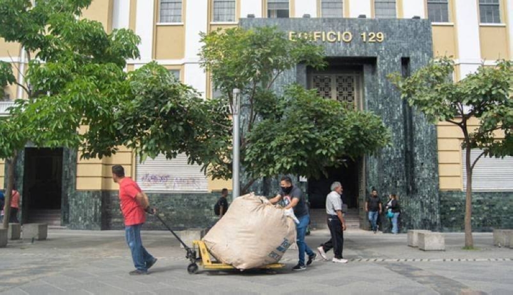 Trabajadores sacaron el viernes los últimos fardos de ropa usada que quedaban en el edificio del exbanco Salvadoreño. / Lisbeth Ayala.