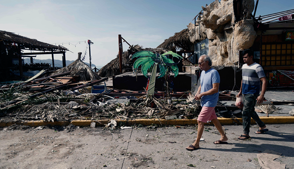 Los lugareños caminan por un área dañada, tras el paso del huracán Otis en Acapulco, estado de Guerrero, México.AFP