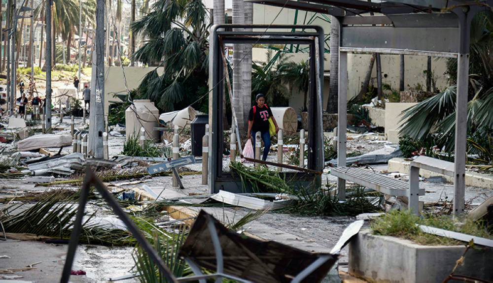 Una mujer camina entre los escombros que quedaron después del paso del huracán Otis en Acapulco, estado de Guerrero, México.AFP