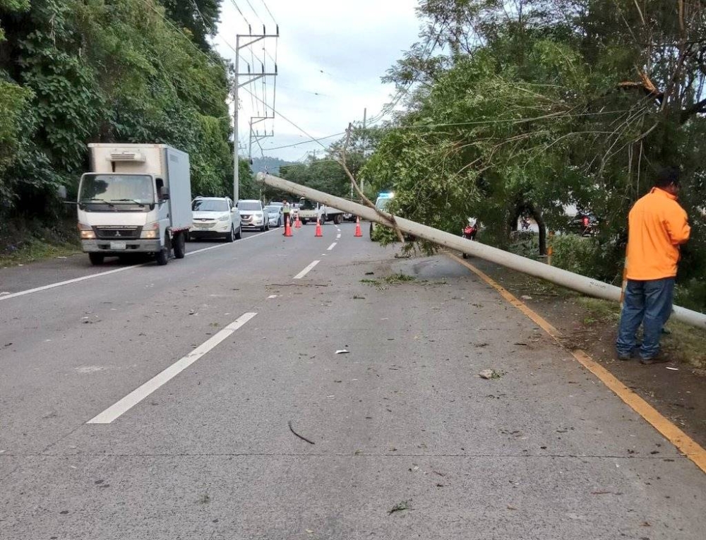 El poste de tendido elèctrico està obstruyendo parte de la vìa, por lo que agentes policiales orientan el tráfico vehicular.