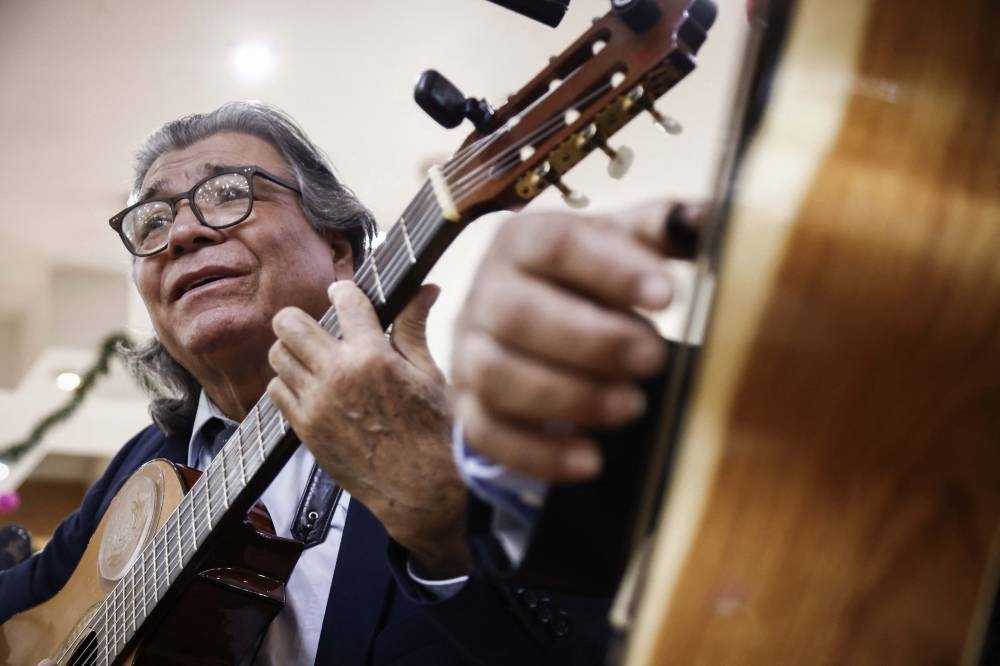Luis Antonio Ferrari, cantante de boleros, toca su guitarra en la Ciudad de México. / AFP