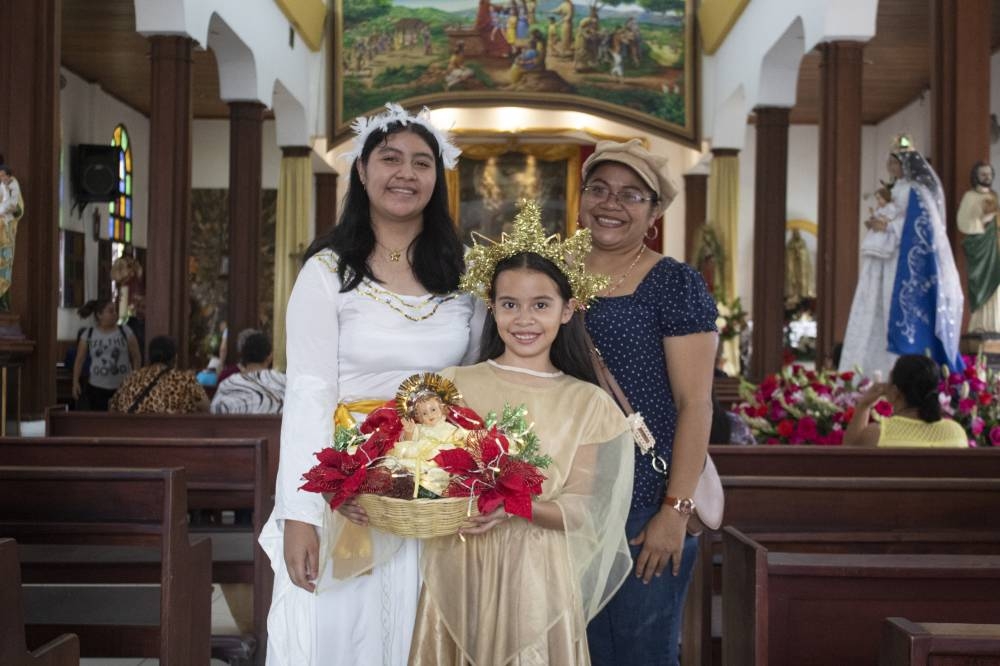 Guadalupe Mancía junto a sus dos hijas en la parroquia de los Santos Niños Inocentes. /Emerson Del Cid
