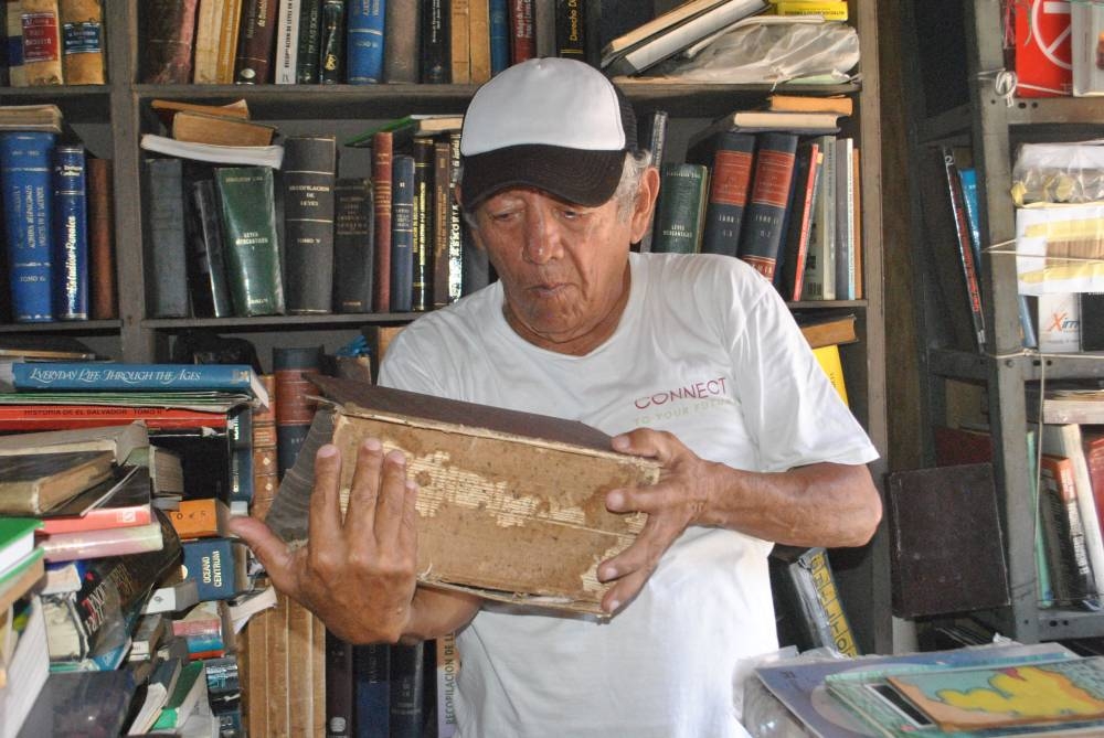 Carlos Humberto Martínez, colaborador de la librería, tiene en manos el libro más grueso de toda la localidad. /Michelle Rivera.