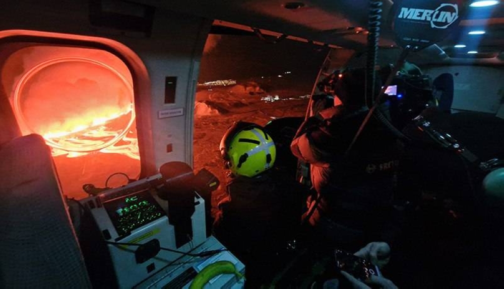 Un camarógrafo de la Guardia Costera de Islandia graba nubes de humo y lava que brotan de una nueva fisura durante una nueva erupción volcánica en las afueras de la ciudad evacuada de Grindavik. AFP. 
