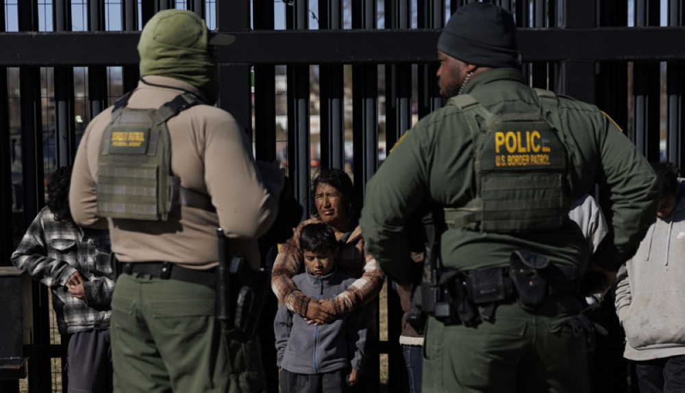 Patrulla Fronteriza de EEUU detiene a migrantes en el muro fronterizo con México. AFP.