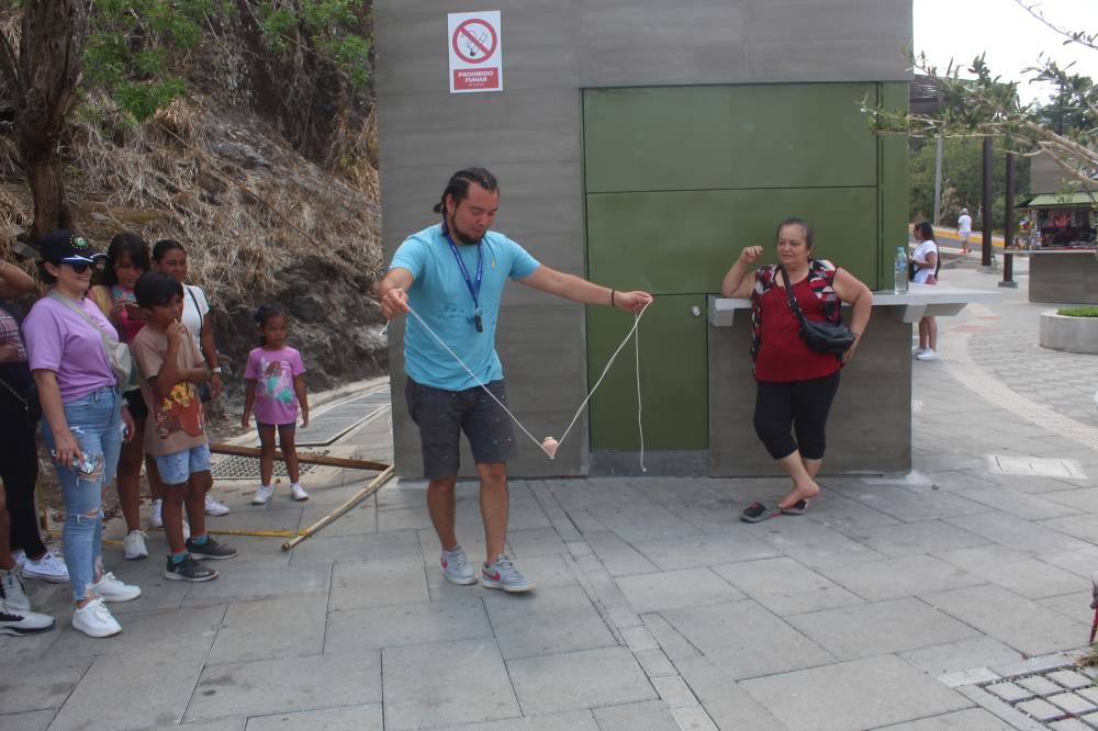 Los turistas se divierten con diferentes actividades, como el juego del trompo. / Michelle Rivera.