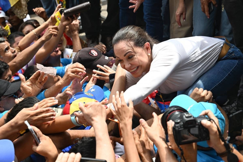 Maria Corina Machado, cuya candidatura fue inhabilitada en Venezuela, es aclamada por el público. / AFP.