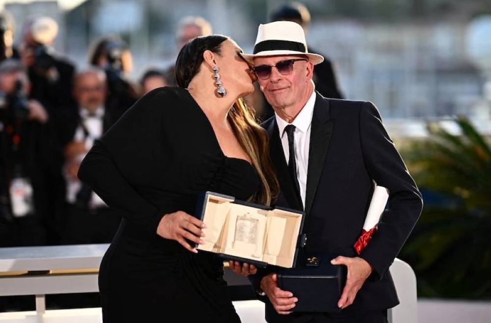 La actriz española Karla Sofía Gascón (izq) besa al director francés Jacques Audiard tras su triunfo en la película 