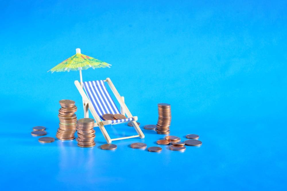 La inflación de restaurantes y hoteles creció 10 veces en los últimos dos años. /DEM,image_description:rising prices for vacation or wealth management concept,heap of coins, sun umbrella and deck chair, free copy space