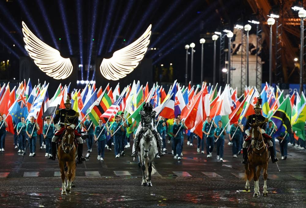 La amazona (C) llega con la bandera olímpica al Trocadero durante la ceremonia de apertura de los Juegos Olímpicos de París 2024 en París el 26 de julio de 2024. (Foto de Stephanie Lecocq / POOL / AFP)