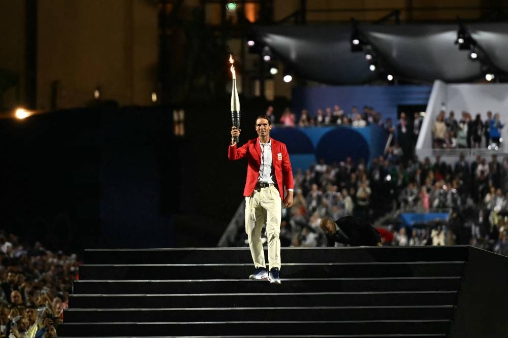 El tenista español Rafael Nadal porta la llama olímpica durante la ceremonia inaugural de los Juegos Olímpicos de París 2024 en París el 26 de julio de 2024. (Foto de MARTIN BERNETTI / AFP)