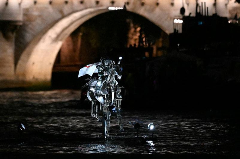 Un caballo mecánico plateado cabalgó por el río Sena. / AFP 