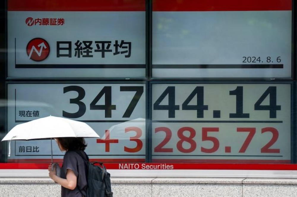 Una mujer pasa frente a una pizarra electrónica del Tokyo Stock Exchange en Tokio, Japón, este martes./ AFP,image_description: