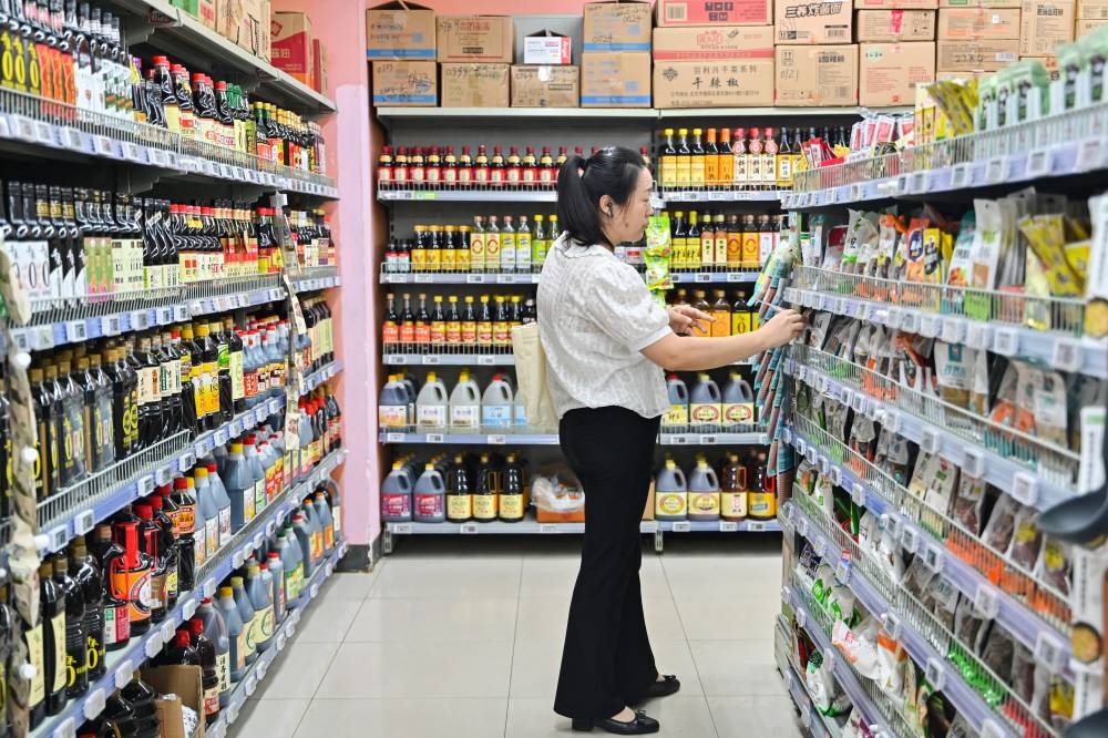 Una mujer compra en un supermercado en Beijing, China. /AFP,image_description: