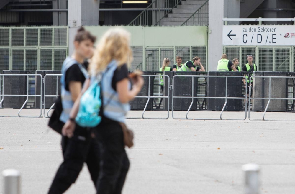 Guardias de seguridad remueven las barreras de los shows cancelados en el estadio Ernst Happel de Viena. / AFP