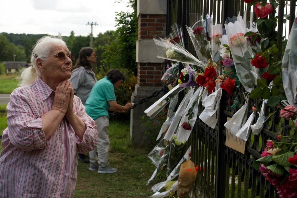 Una mujer aprecia los tributos dejados en el hogar del actor, en Douchy, Francia. Photo by GUILLAUME SOUVANT / AFP