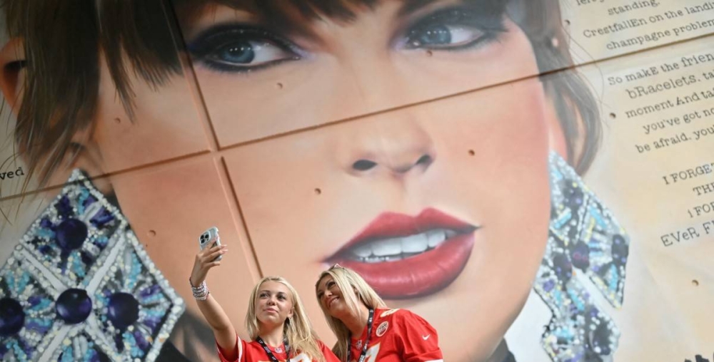 Fans de Taylor posan junto a una pintura urbana en el estadio Wembley de Londres, en los últimos días de su gira europea. / AFP,image_description: