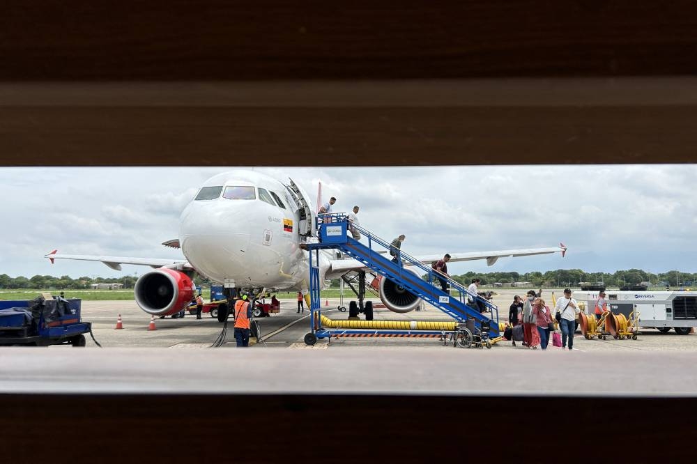 Pasajeros descienden de un avión de Avianca en el aeropuerto internacional de Cartagena el 02 de agosto de 2024. Foto Luis ACOSTA / AFP,image_description: